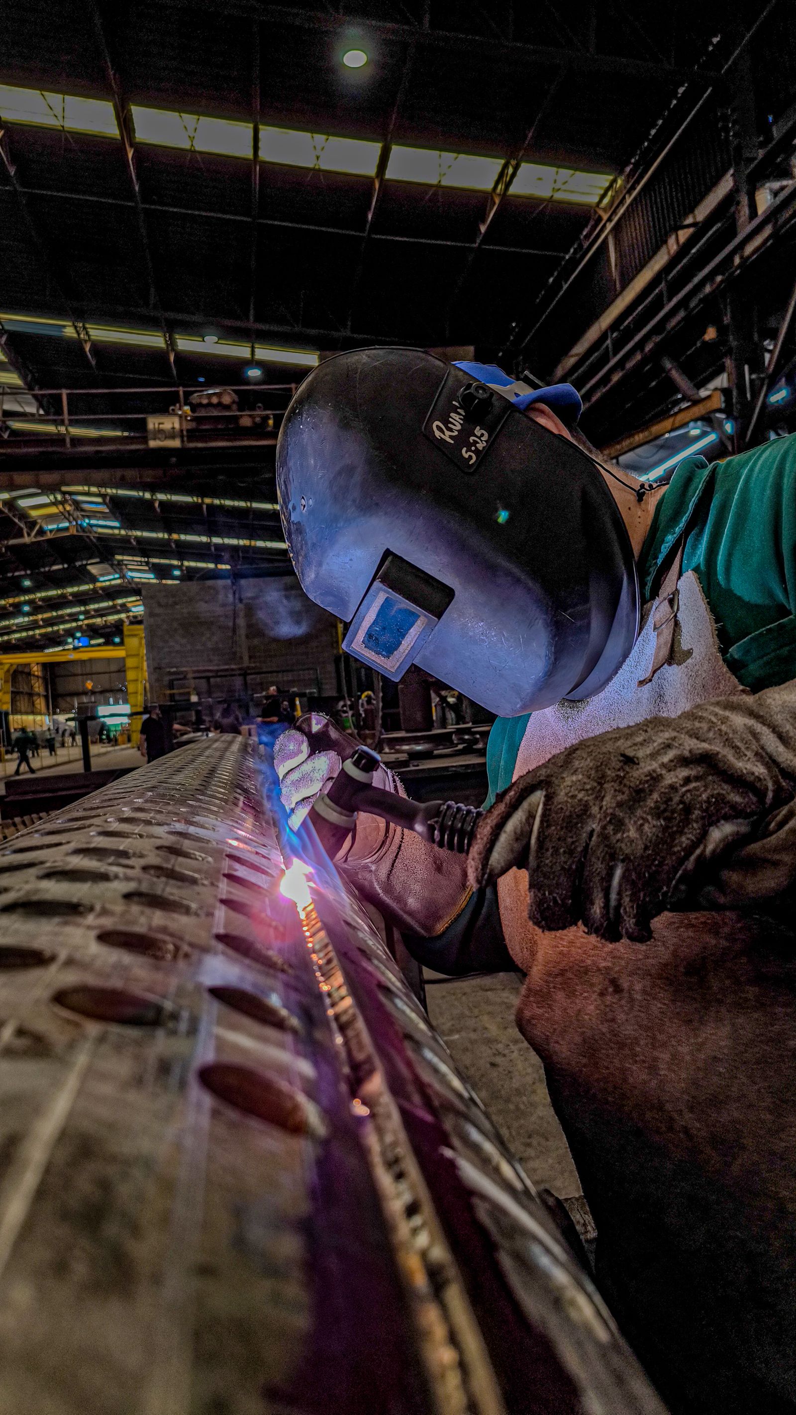 Metal fabricator welding a custom component in a workshop