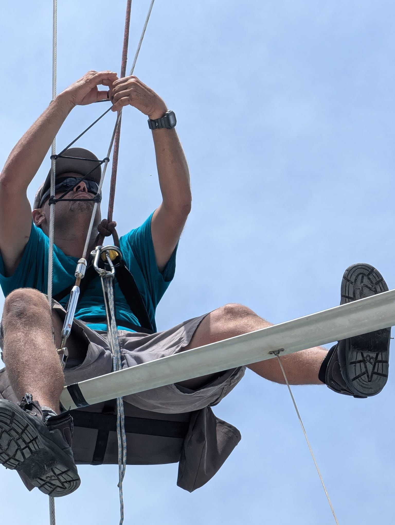 Yacht rigger working aloft on standing rigging